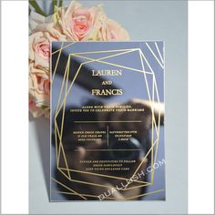 the front and back of a wedding card with gold foil on it, next to flowers