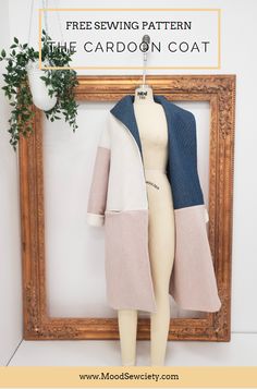 a mannequin is standing next to a wooden frame with a plant in it