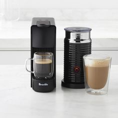 an espresso machine, coffee cup and other items sit on a counter top