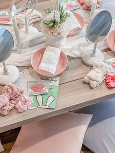 a table topped with pink dishes and mirrors