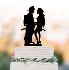 a silhouette of two people standing next to each other on top of a white cake