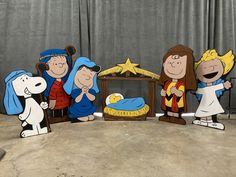 some cartoon characters are standing in front of a nativity scene