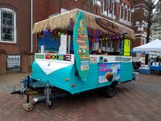 an ice cream truck parked in front of a brick building with lights on the roof