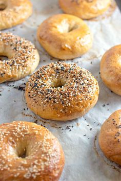 bagels with sesame seeds and poppy seed sprinkles on a baking sheet