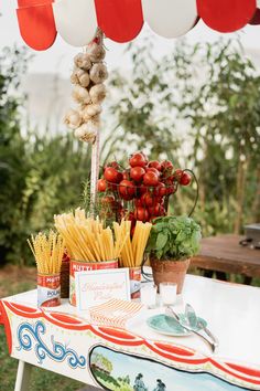 a table topped with lots of different types of food on top of a white table