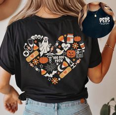 a woman wearing a black shirt with halloween icons on it