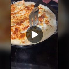 someone is cutting cheese into a pizza in a skillet