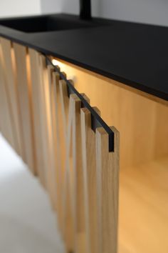 a black counter top with wooden slats on it