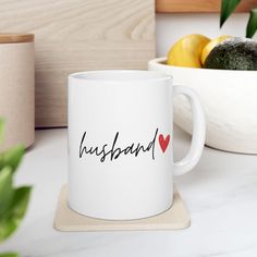 a white coffee mug with the word husband on it