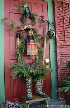 the front door is decorated with christmas wreaths and boots