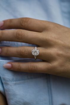 a woman's hand with a diamond ring on it