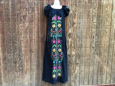 An ethnic, festive dress that is embellished with floral embroidery. No stretch at neckline.  Size large. Good condition.  Measurements taken across front laid flat Bust21" Shoulder to hem59" Waist20" Fitted Black Dress For Festivals, Traditional Black Fiesta Dress, Traditional Black Dress For Fiesta, Traditional Black Embroidered Dress For Fiesta, Fitted Multicolor Embroidered Dress For Festivals, Black Floral Embroidered Dress For Festival, Black Fitted Embroidered Dress For Festival, Fitted Black Festival Dress, Fitted Embroidered Dress With Floral Embroidery For Festivals