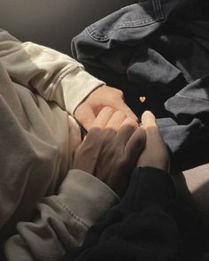 two hands holding each other while laying down