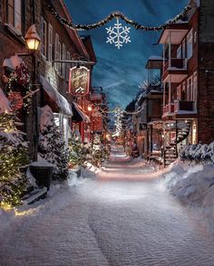 a snowy street with christmas lights and decorations