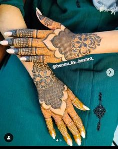 a woman's hands with henna tattoos on her arm and hand, showing the design