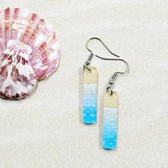 Lightweight and colorful, these earrings are on clear acrylic and feature beach waves and sand. The 1.5 inch clear acrylic bar is dainty with a width of just .33 inches. All findings are stainless steel and include rubber backings to keep secure.  Nickel-free and lead-free.  Perfect summer gift for those headed to the beach or just missing the waves. Ready to ship! Drop length is 2.00 inches. Please see photo for size reference.  🤍 Please note that pattern placement will vary slightly with each Blue Resin Jewelry For Summer, White Resin Earrings For The Beach, Resin Drop Earrings For Beach, Resin Dangle Earrings For Beach, Resin Earrings For Summer Beach, Summer Beach Resin Earrings, Rectangular Summer Earrings As Gift, White Resin Earrings For Summer, Minimalist Earrings For Beach And Summer