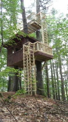 a tree house built in the woods on top of a hill