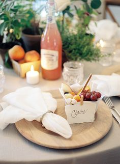 a table set with plates, napkins and wine bottles