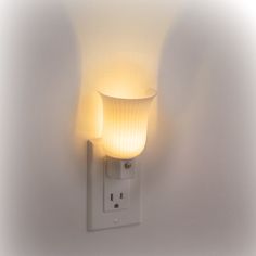 a light that is on the side of a wall with a white lamp attached to it