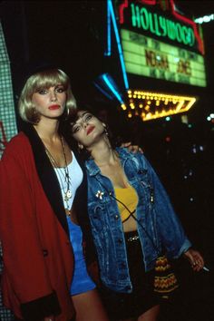 two women are posing for the camera and one is wearing a jean jacket