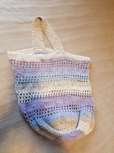 a crocheted bag sitting on top of a wooden table