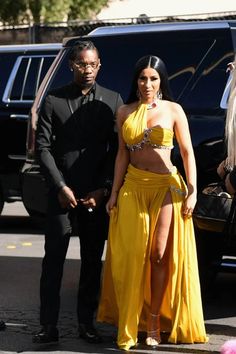 a woman in a yellow dress standing next to a man