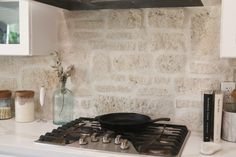 a stove top oven sitting inside of a kitchen next to a wall mounted pot on it's side