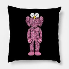 a black pillow with a pink teddy bear on it's face and two yellow eyes