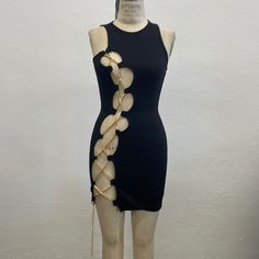 a mannequin wearing a black dress with gold chains on it