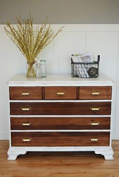 a white and brown dresser sitting on top of a hard wood floor