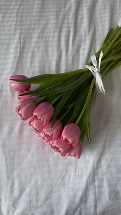 a bunch of pink tulips on a white sheet