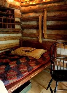 a bed in a log cabin with lights on the ceiling and a chair next to it