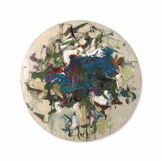 an abstract painting on a white plate with blue and green paint splattered all over it