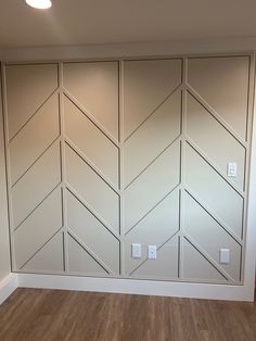 an empty room with wood flooring and white painted wall paneling on the walls