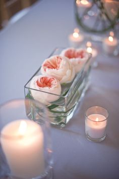 candles and flowers in glass vases on a table