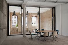 an empty room with tables and chairs in front of large glass doors that look out onto the street