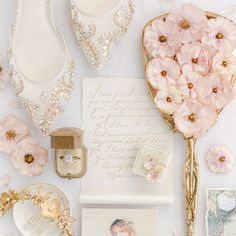 a table topped with pink flowers and wedding accessories