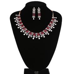 American Diamond bridal collar choker necklace studded with ruby red and clear CZ stones encrusted on rose gold background. Necklace comes with a pair of matching earrings. This is very unique and beautiful Indian Necklace set studded high quality AD stones beautifully decorated work. Stone shape: emerald cut and Pear Necklace Length: 9 inches+ Length of Extender is 9 inches Earring Length: 1.75 inches Contents: 1 Necklace, 2 Earrings Best suitable for Party Wear / Fashion Wear for Any Occasion. Rose Gold Ruby Jewelry For Parties, Red Bridal Necklace With Sparkling Stones For Wedding, Elegant Red Choker Jewelry Sets, Red Rhinestone Wedding Jewelry, Red Diamond Necklace For Party, Elegant Red Rhinestone Necklaces, Red Bridal Choker Necklace For Celebration, Red Choker Bridal Necklace For Celebration, Red Crystal Necklaces For Celebrations