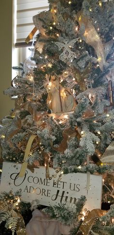 a white christmas tree with gold and silver decorations