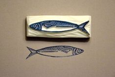 two fish are shown on the wall next to each other, one is blue and white