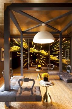 a living room filled with lots of furniture and yellow flowers in vases on the wall