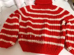 a red and white striped sweater hanging on a rack