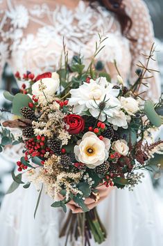 a bride holding a red and white bouquet