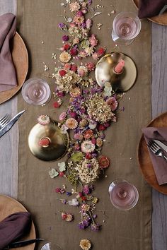 the table is set with flowers and silverware