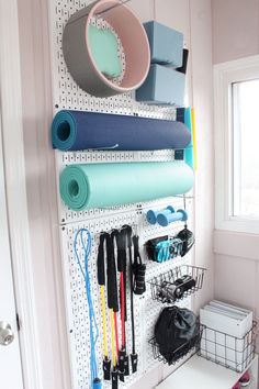 a pegboard with various items hanging on it and a basket in front of it