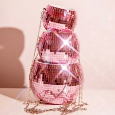 three pink disco ball purses stacked on top of each other with chains around them