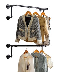 three jackets hanging on a rail with two coat hangers