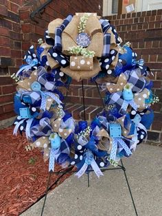 a blue and white wreath on top of a metal stand in front of a brick building