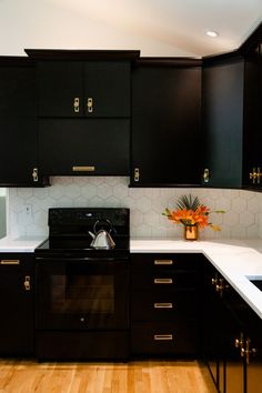 a kitchen with black cabinets and white counter tops