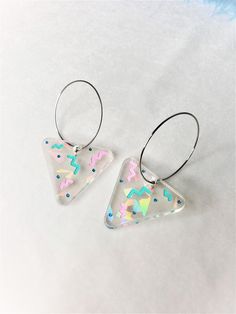 Rainbow Triangle 80s Holiday Party Hoop Earrings The hoops are made of stainless steel, they are about 1.25 inches acrossApproximately 1.25" wide, and 2.25" long from top of metal hoopThese are super fun and colorful earrings. Bright and cheery! With the lovely pastels and retro vibes, these earrings should give a good mood booster. They are made with a clear acrylic that feature rainbow iridescent shards of glitter, that shines differently depending on the light. The engraved details are hand p Pink Fun Hoop Earrings As Gift, Fun Pink Hoop Earrings For Gift, Fun Pink Hoop Earrings As Gift, Playful Pink Hoop Earrings Gift, Playful Hoop Earrings As Gift, Playful Multicolor Hoop Jewelry, Fun Handmade Hoop Earrings, Retro Hoop Earrings For Parties, Colorful Handmade Fun Hoop Earrings